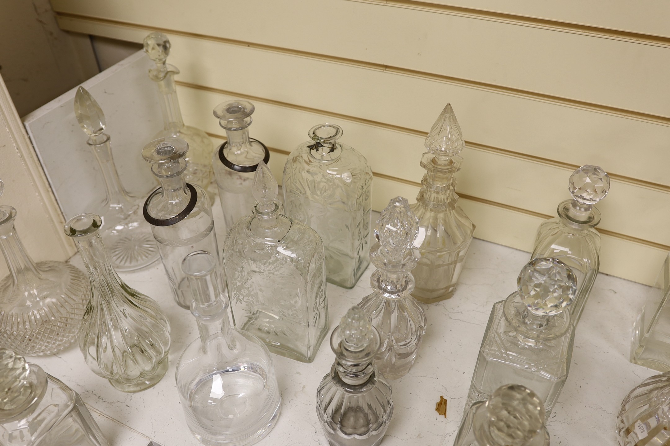 A quantity of various glass decanters, some silver mounted